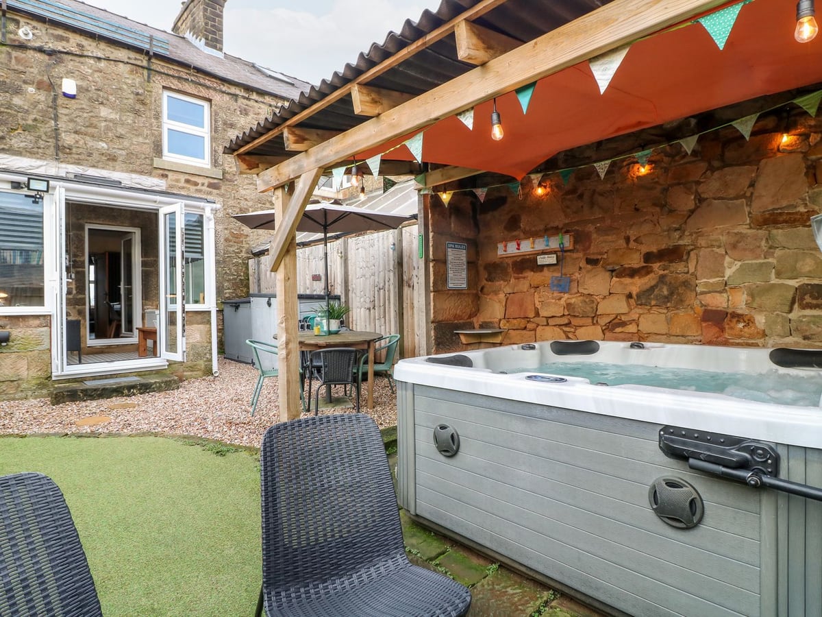 Covered hot tub and garden seating beside the glazed rear doorway of 3 Sunnyside Terrace