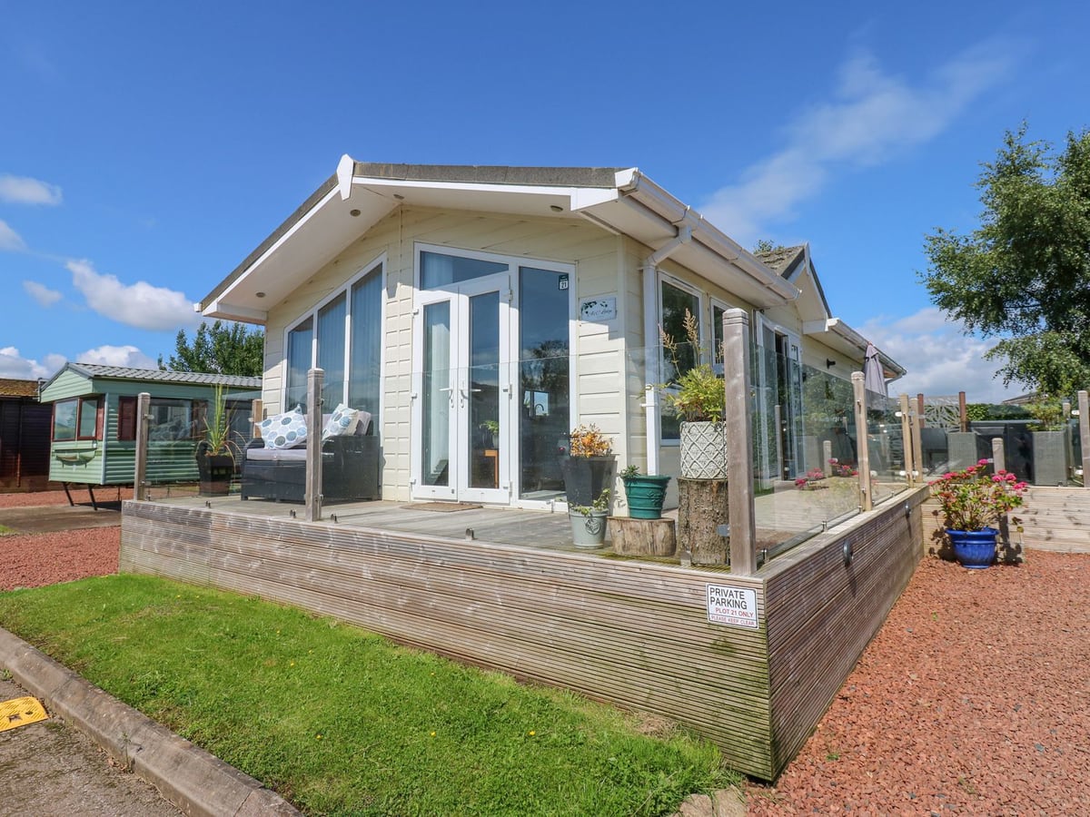 A and C Lodge Plot 21 with glass deck panels, potted plants and white double doors