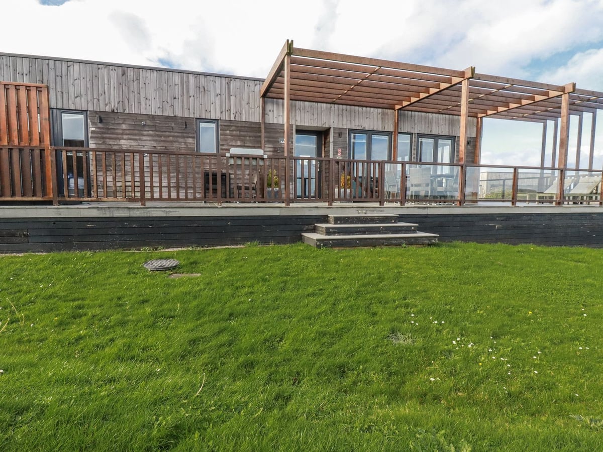Adelaide's timber exterior beside a lawn, with steps to a raised deck and wooden pergola