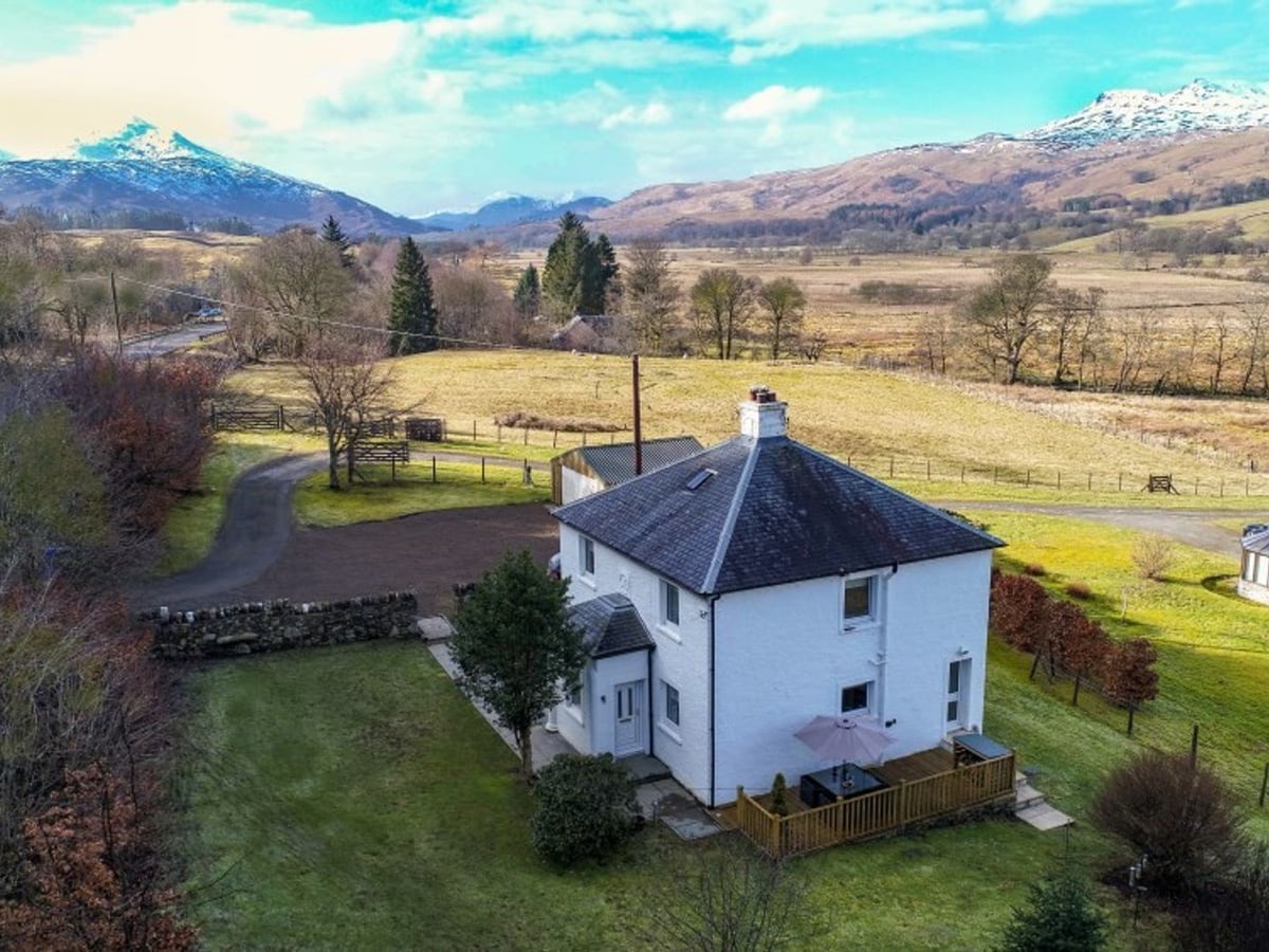 Ardchyle House and its lawn and deck, seen from above with fields and hills behind