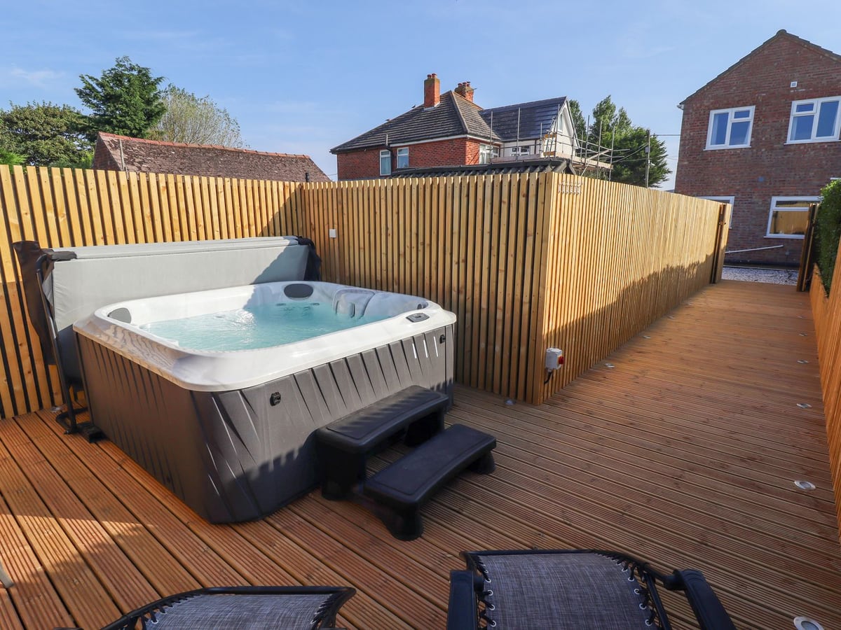 Hot tub and loungers on Beach Haven's timber-screened deck in Anderby Creek