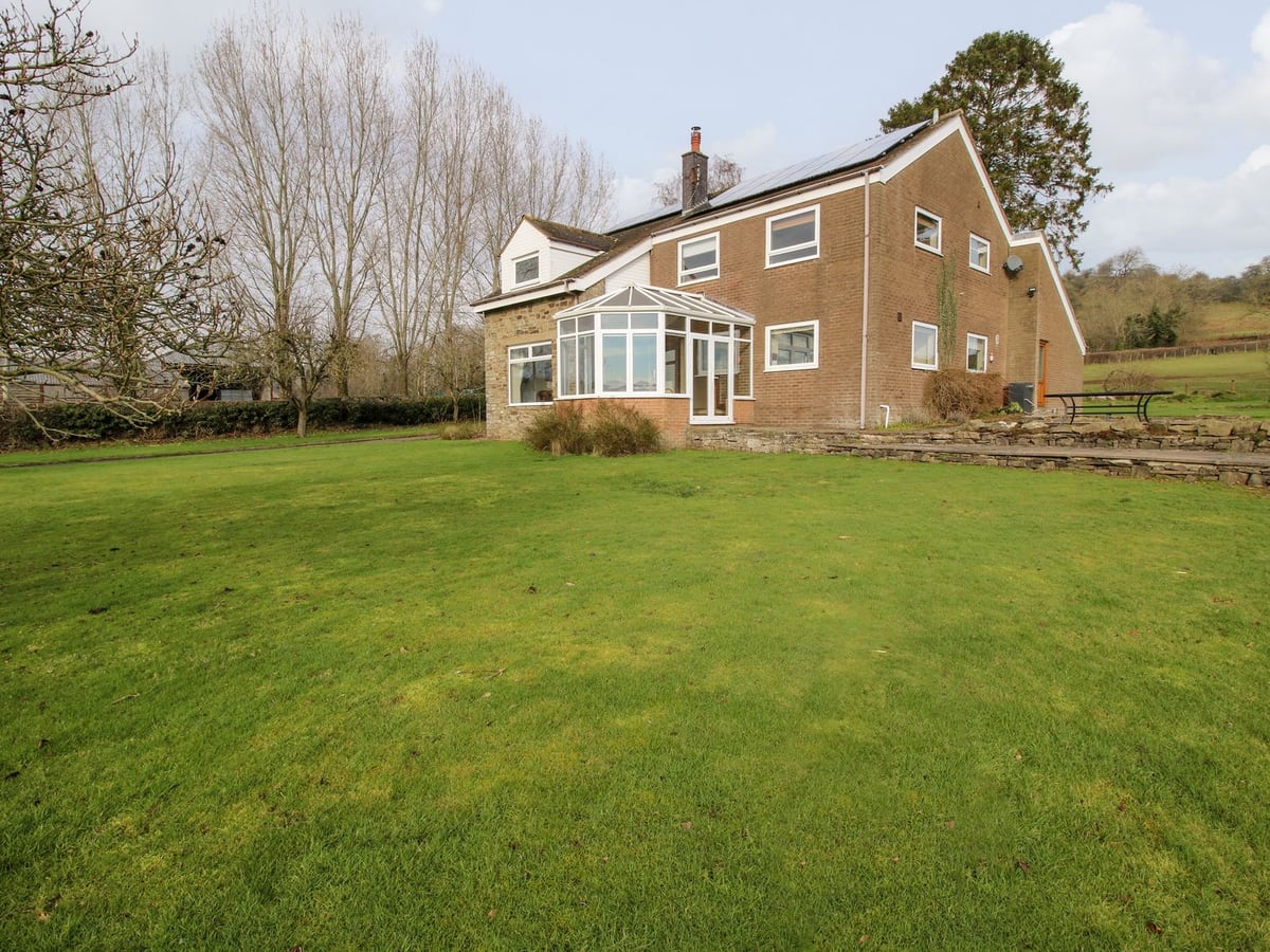Bicton Lea's house and conservatory facing a broad lawn with stone terrace edging
