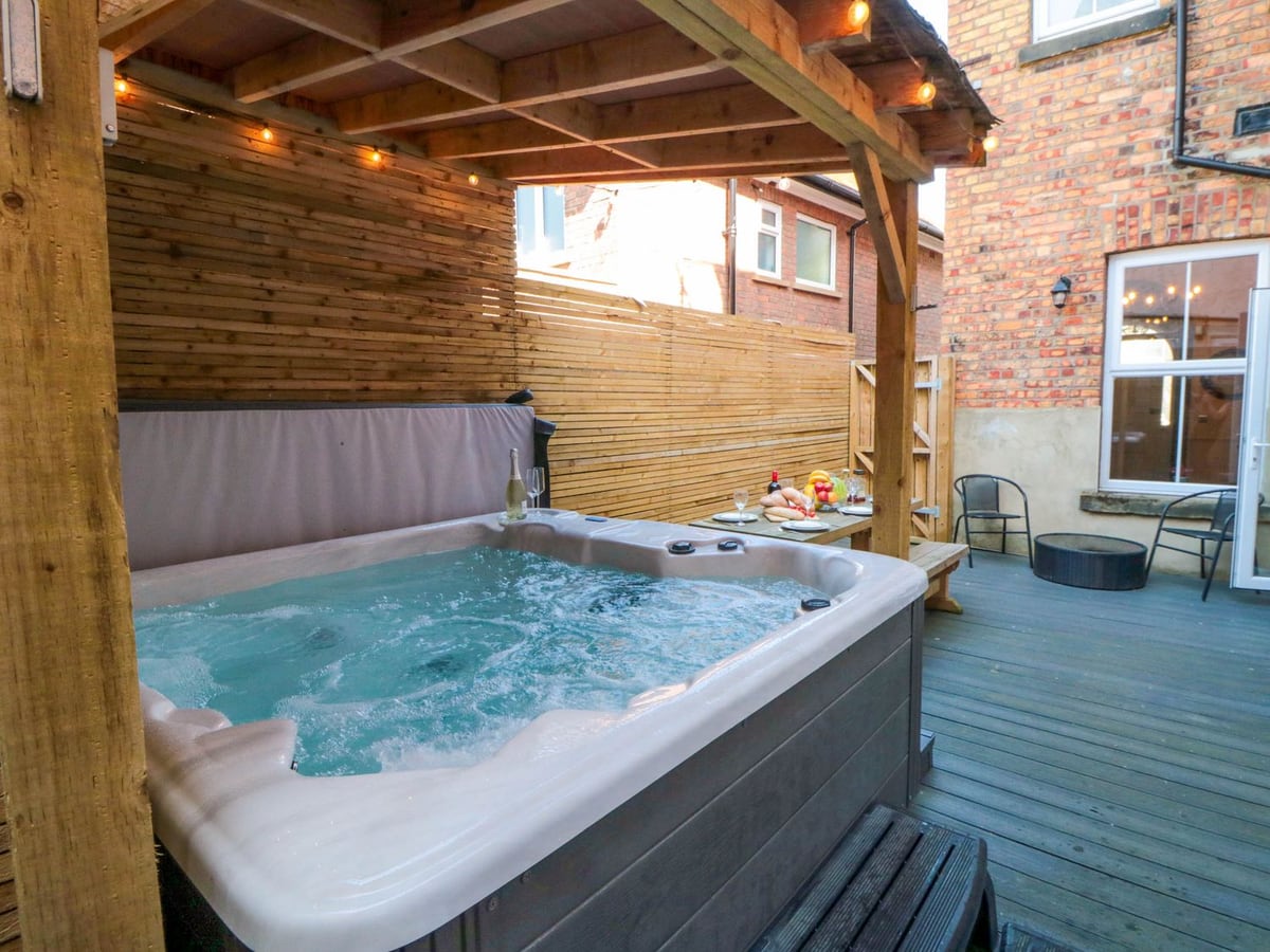 Covered hot tub and walled outdoor dining area at Coronation House in Scarborough