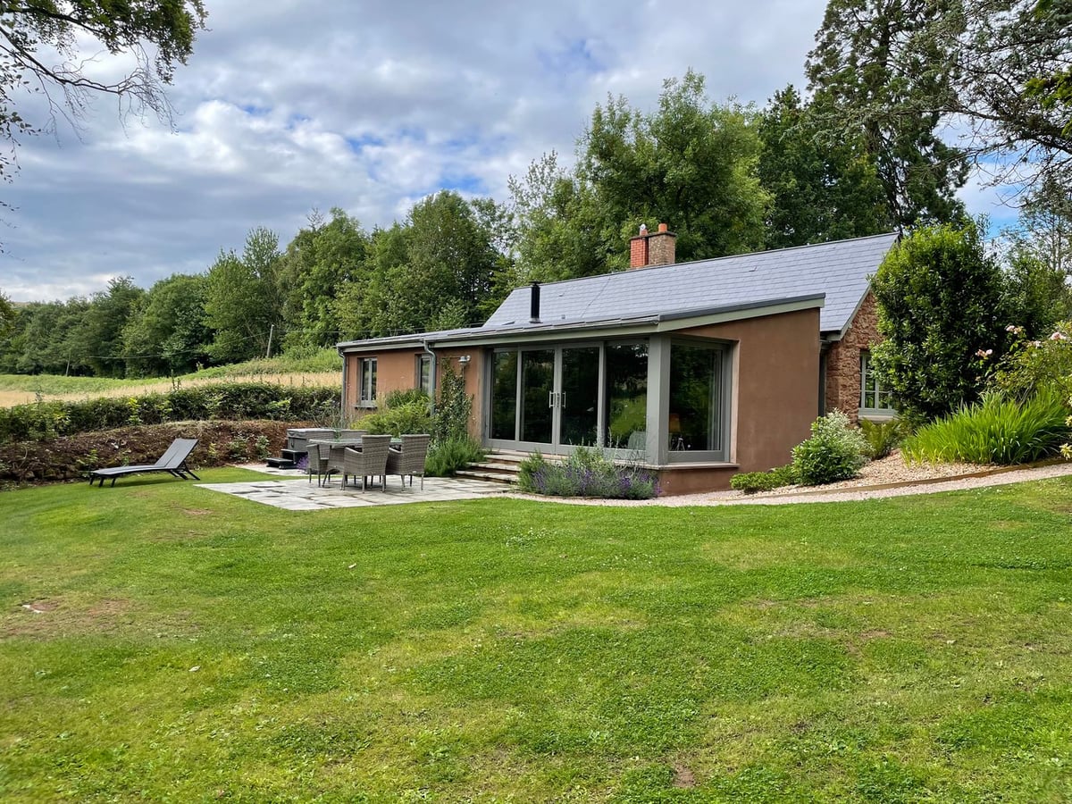 Court Lodge lawn with patio dining furniture and trees beside the house in Bathealton