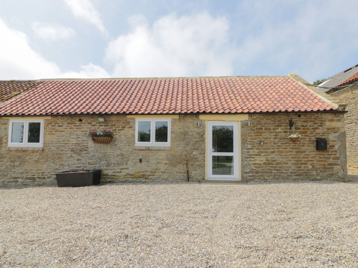 Stone cottage exterior with gravel courtyard and red-tiled roof at Crabtree Cottage