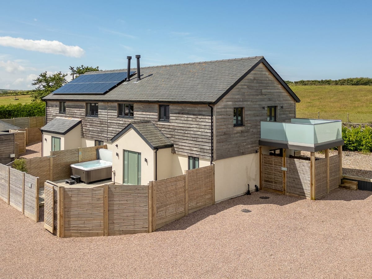 Farmyard House timber-clad exterior with courtyard, hot tub and first-floor balcony