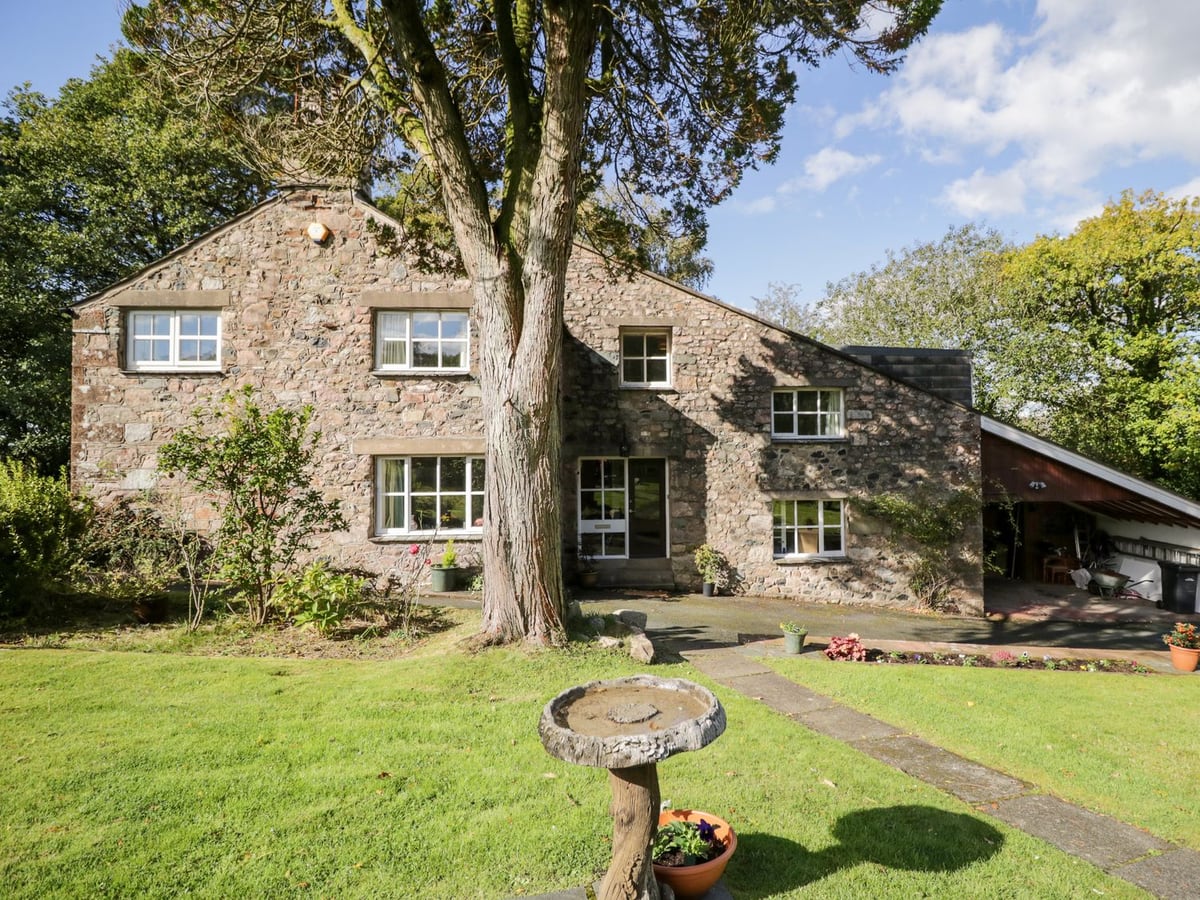 Fell Foot stone house with a lawn, mature tree and birdbath beside the path to the door