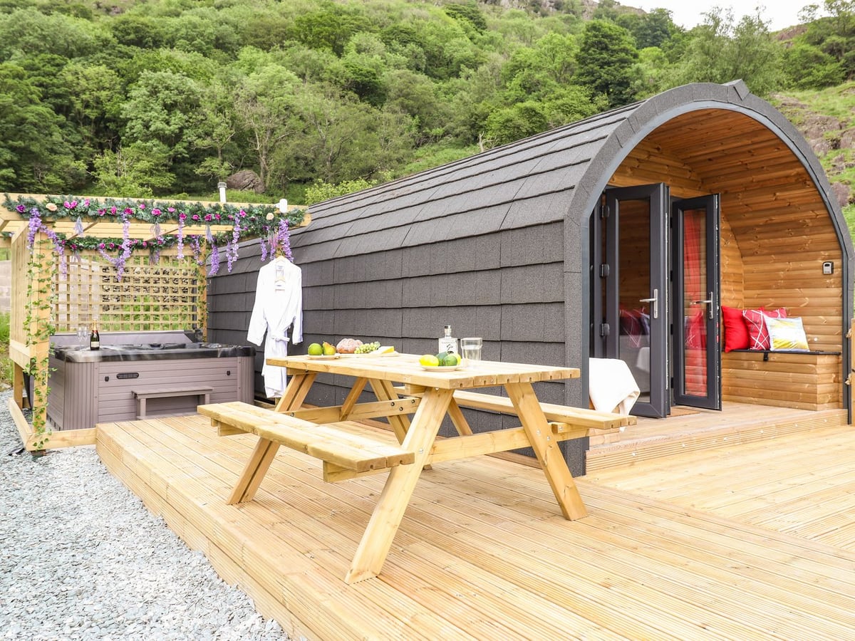 Hartsop Magic timber pod beside a picnic table and hot tub with a trellis surround