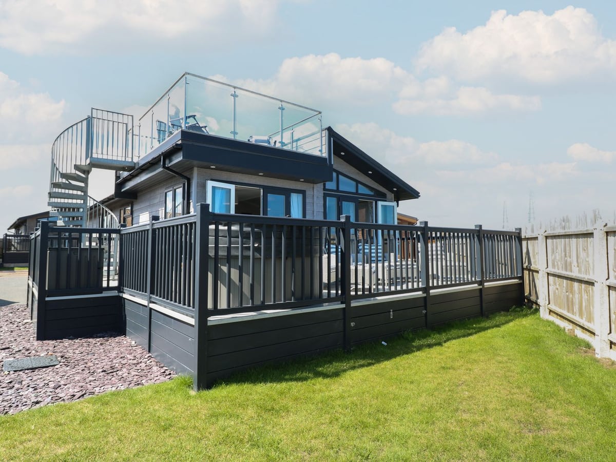 Life's a Beach lodge with raised decking, a spiral staircase, roof terrace and lawn