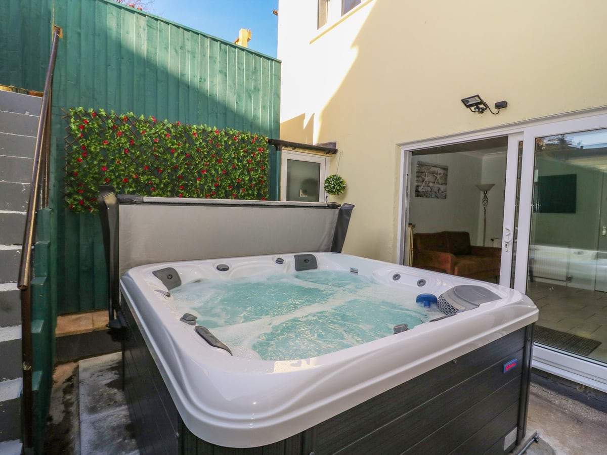 Enclosed patio with hot tub beside the living room doors at North Beach Lodge