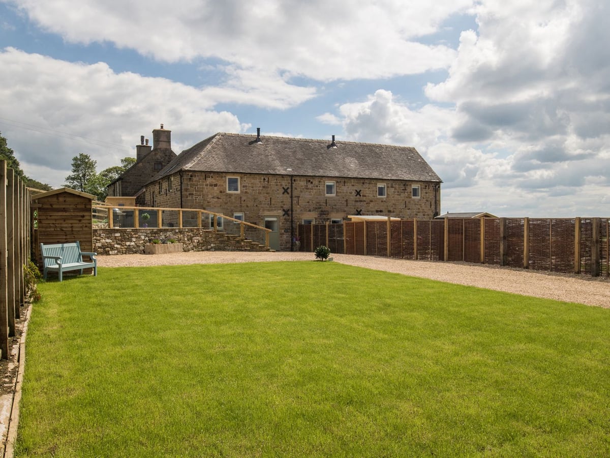 Lawn and gravel path beside the stone walls and timber fencing at Parlour Barn.