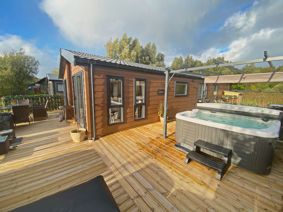 Pine Lake View lodge with wraparound timber decking, outdoor seating and an open hot tub