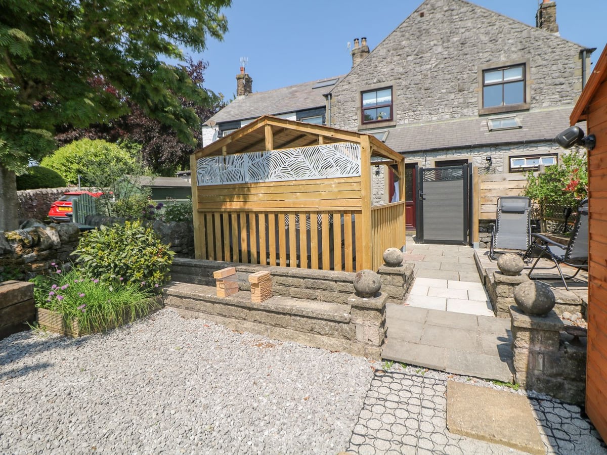 Stone exterior and stepped patio at Shenton Terrace, with a timber gazebo and gravel area