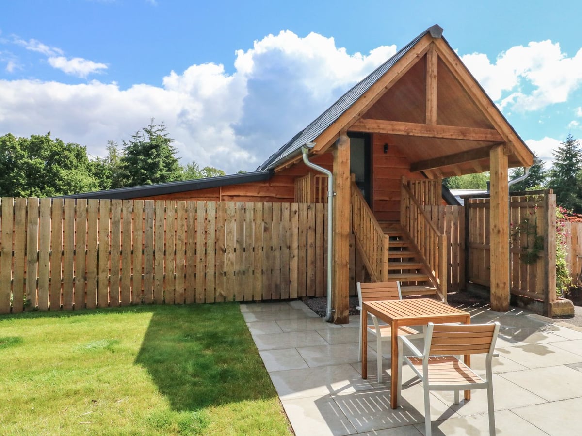 Timber gable and outside steps rising above the lawn at Spicery Barn Loft