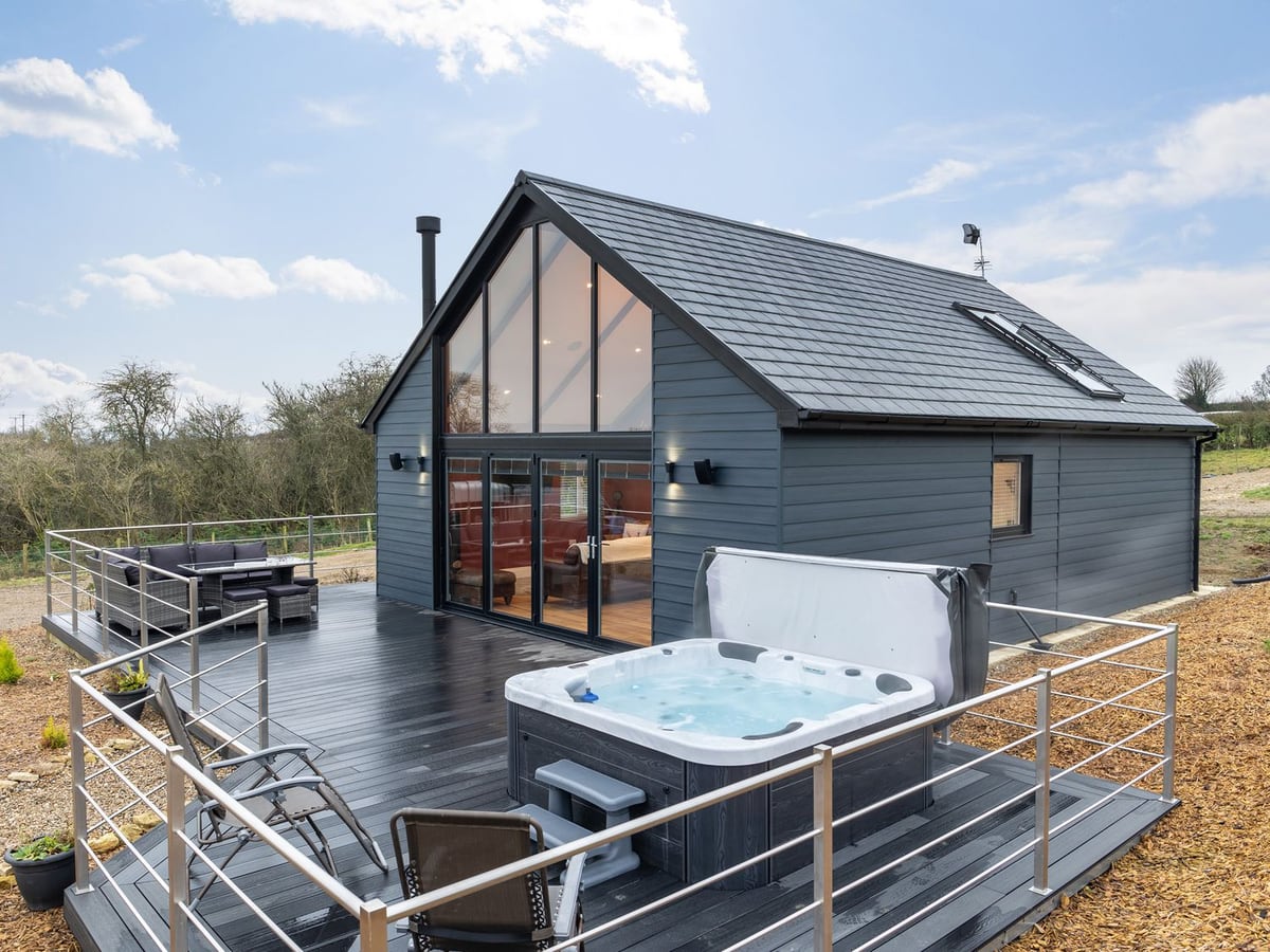 Stags Mount lodge with a hot tub, outdoor seating and metal railings around the deck