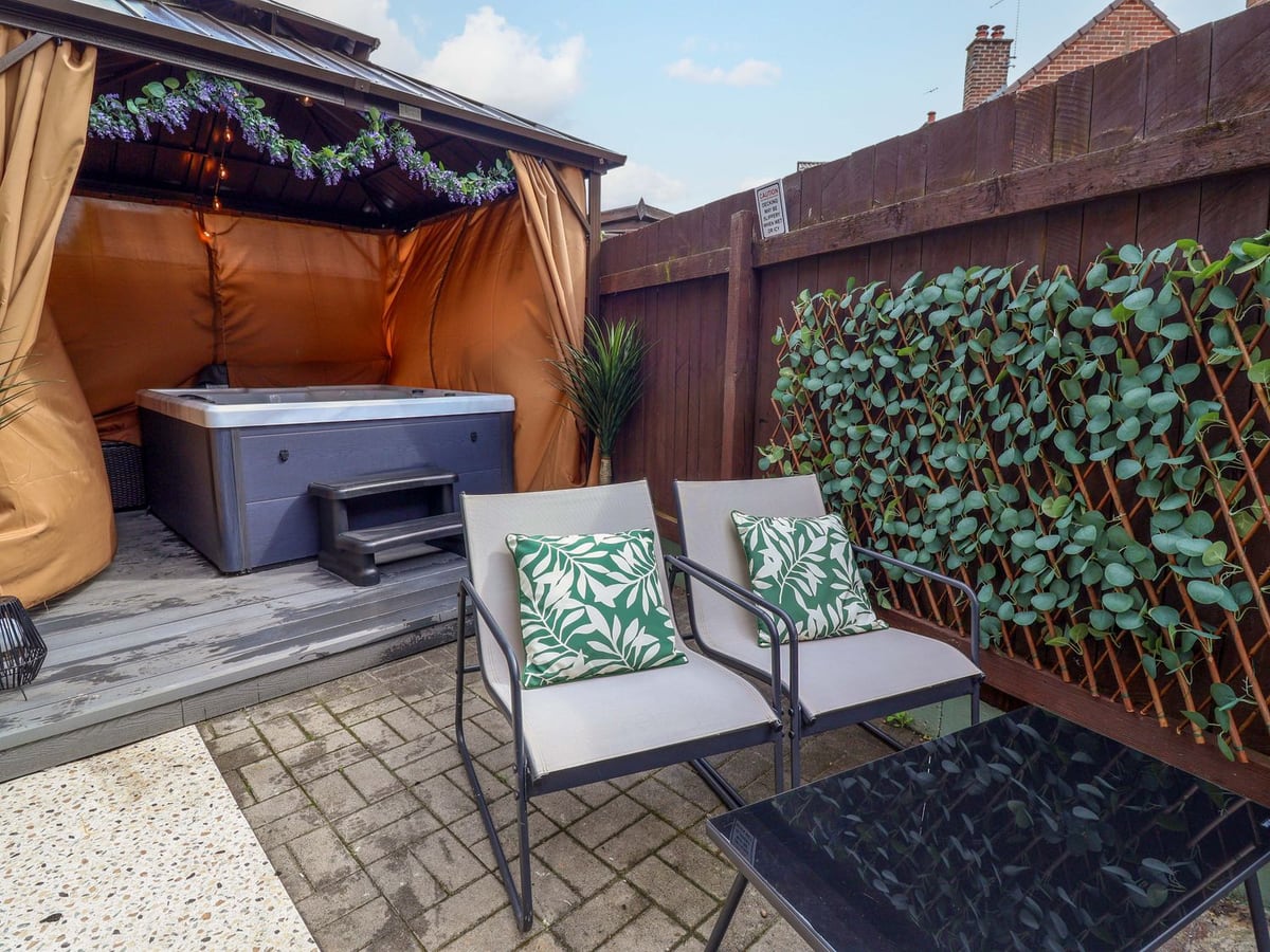 Covered hot tub and patio chairs in the small courtyard at Steam and Stay Hoole