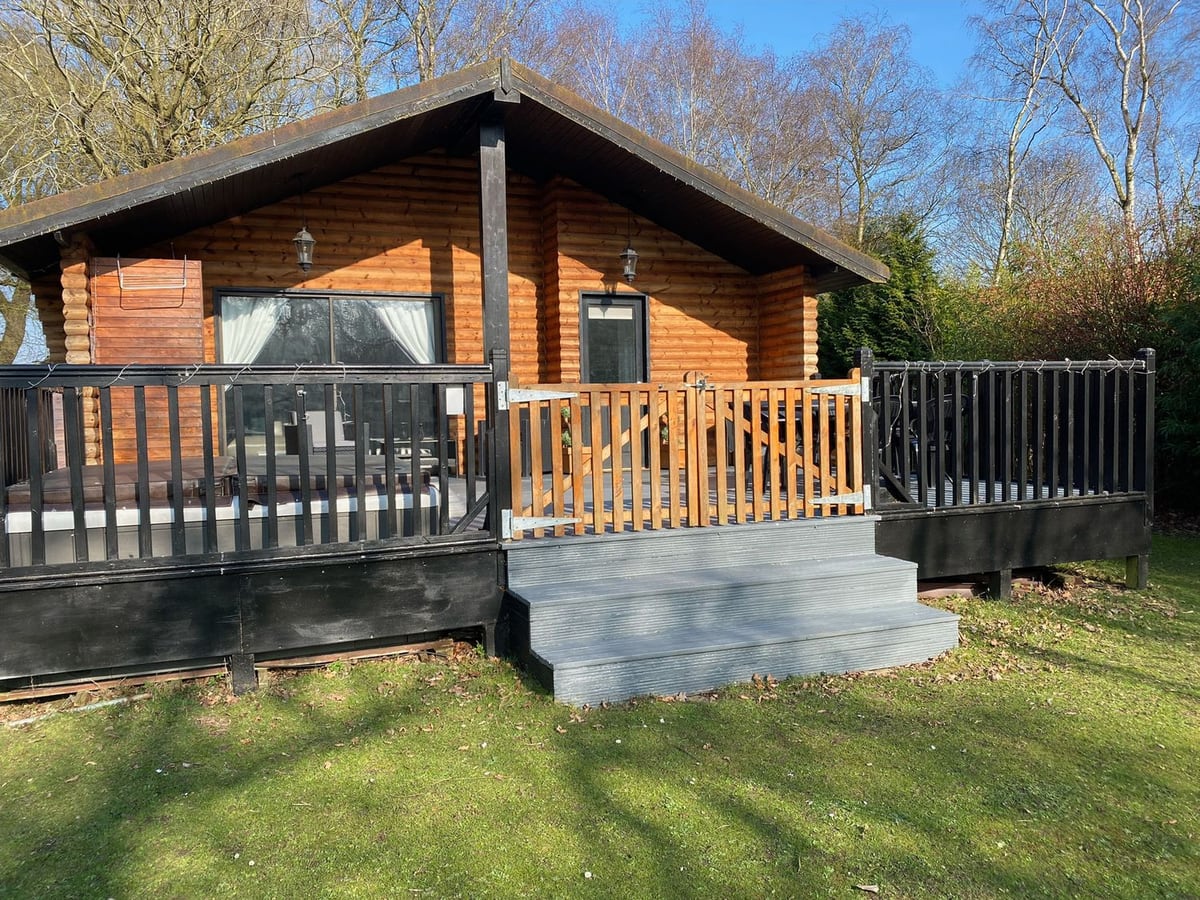 Timber gable, gated decking and steps to the lawn at Sunset Lodge in Tattershall