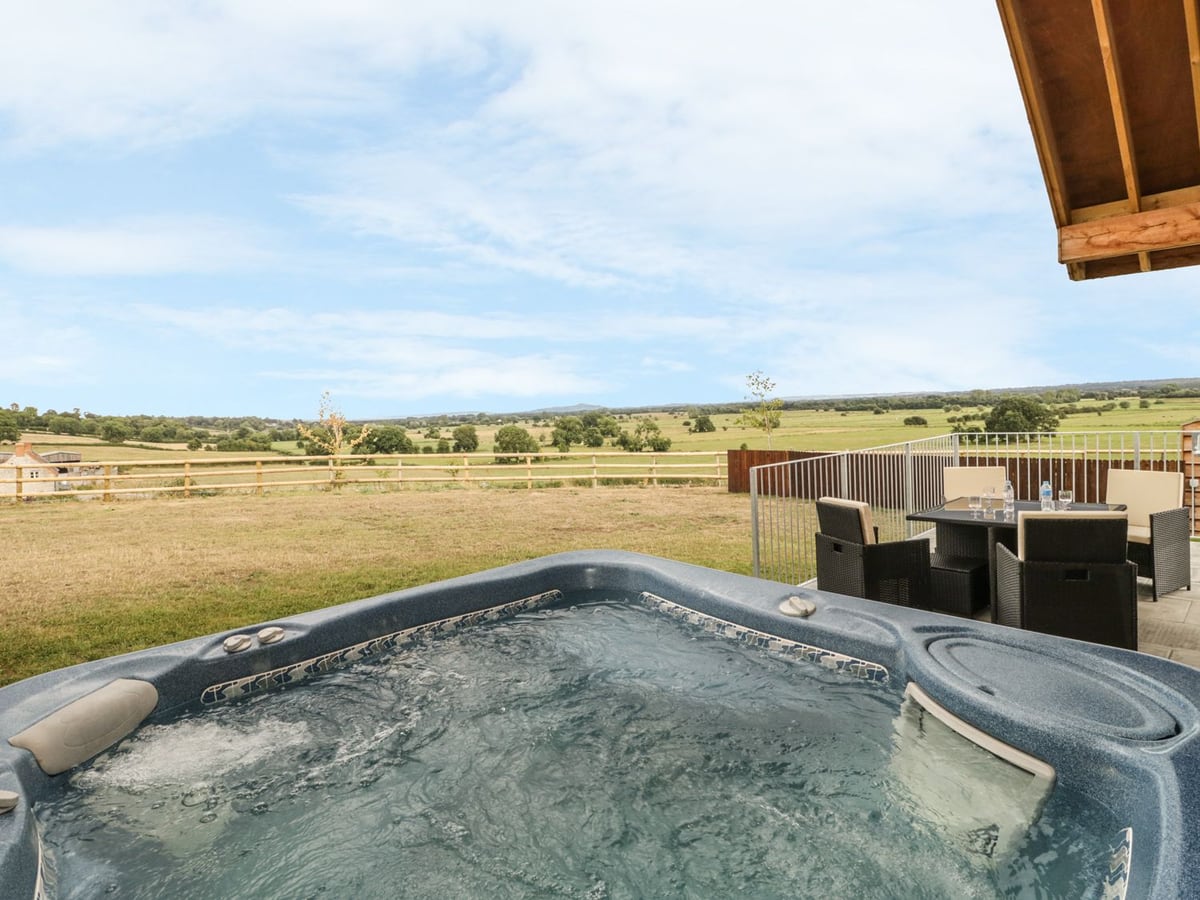 Swan Lodge Castle Farm hot tub and patio facing open farmland near Wedmore