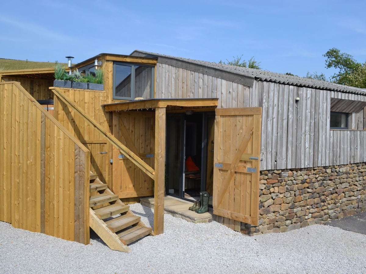 The Barn at Copy House Hideaway with timber cladding and stairs to its raised deck