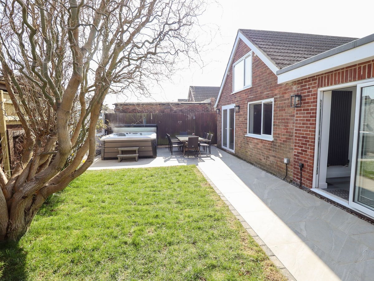 Lawn leading to the hot tub patio beside The Beach Haven in Mablethorpe