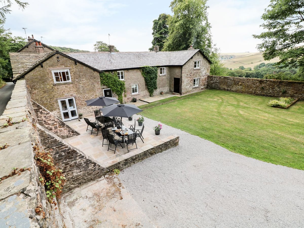 Stone cottage, lawn and outdoor dining terrace at The Bothy near Wildboarclough
