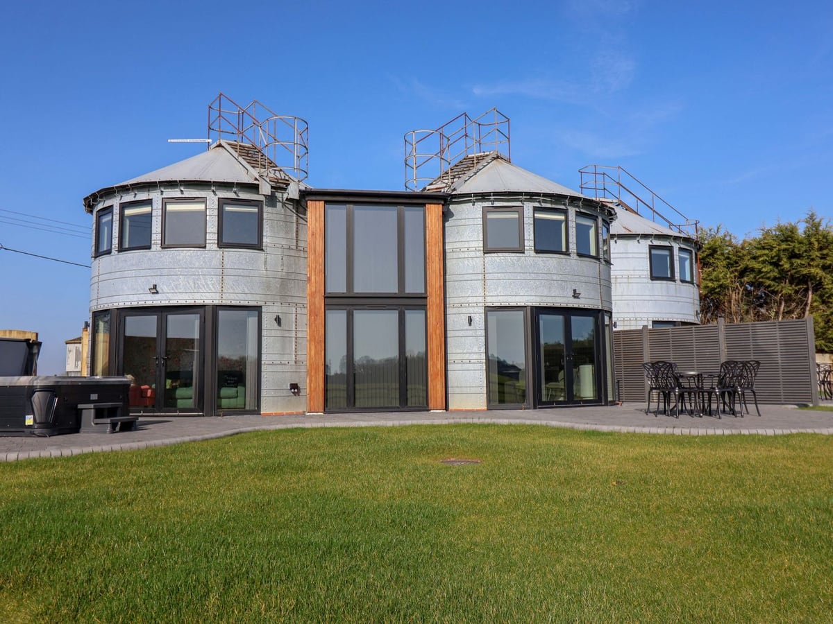 The Corn Silo exterior with round metal silos and patio