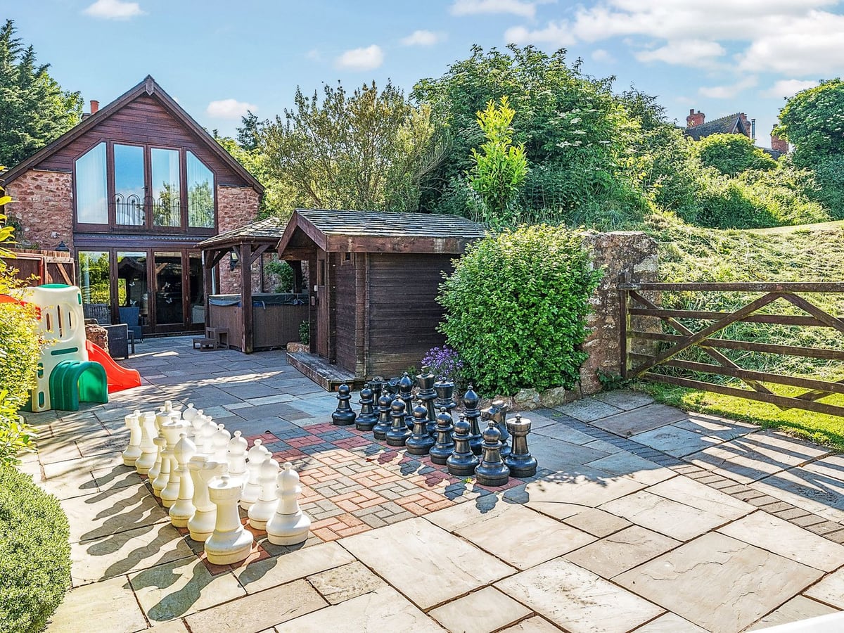 The Linhay patio with play equipment and stone cottage exterior in Washford
