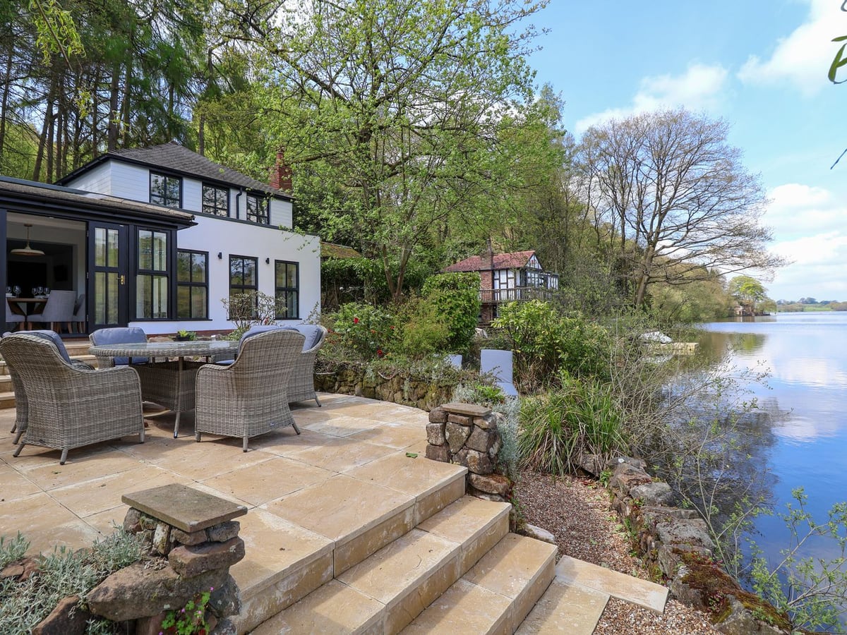 Stone steps beside The Sheiling lead from a furnished terrace towards the open lakeside.