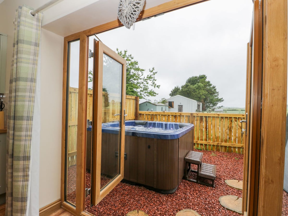 Fenced patio with hot tub and countryside views at Wagtail Nest, Northfield Cottage