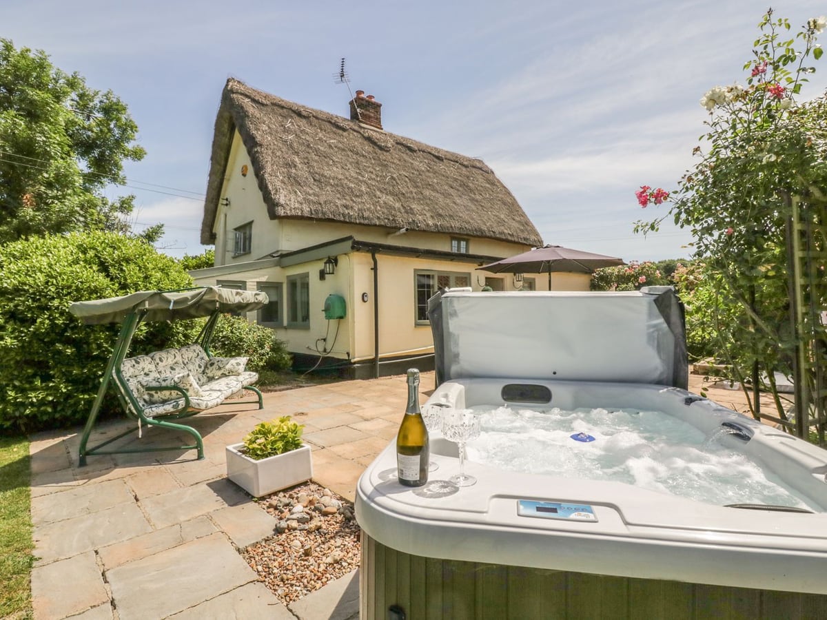 Thatched Waveney Cottage patio with hot tub and garden swing